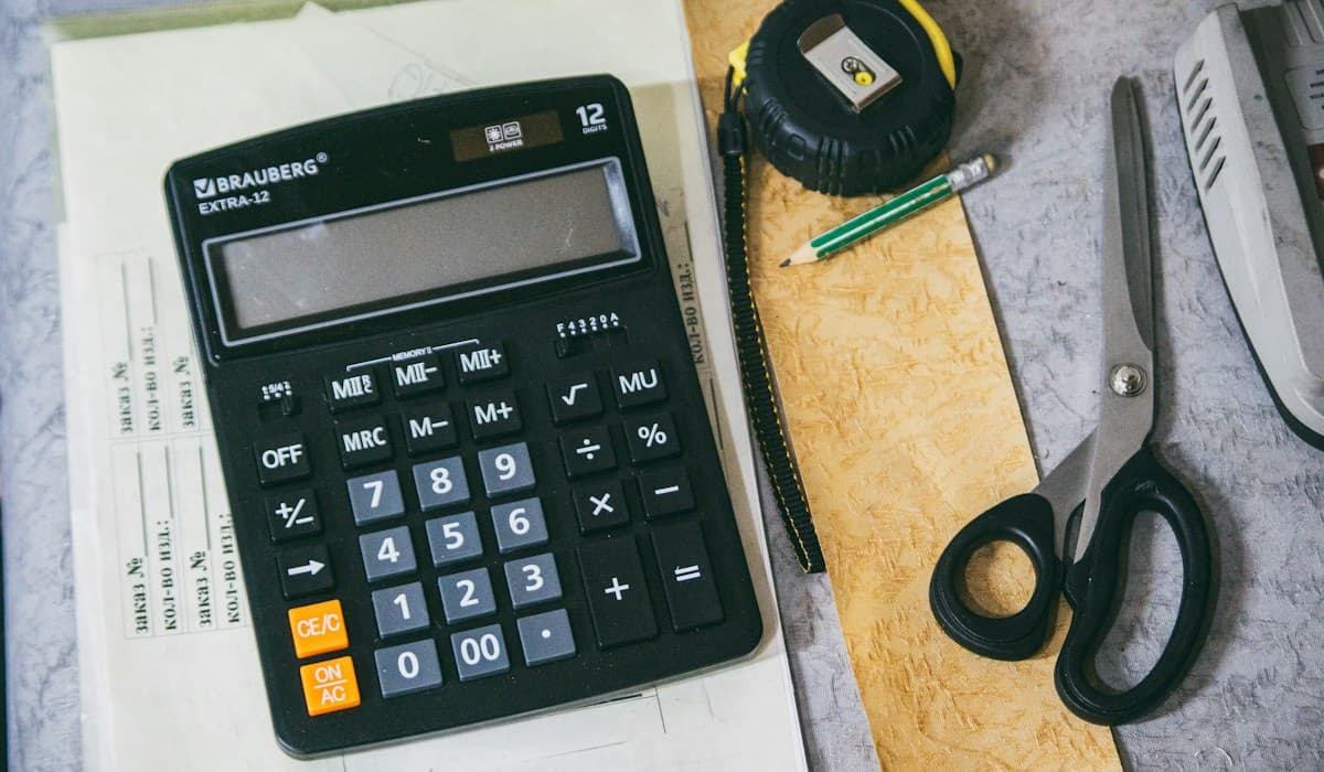 Calculatrice et fournitures de bureau sur une table de travail